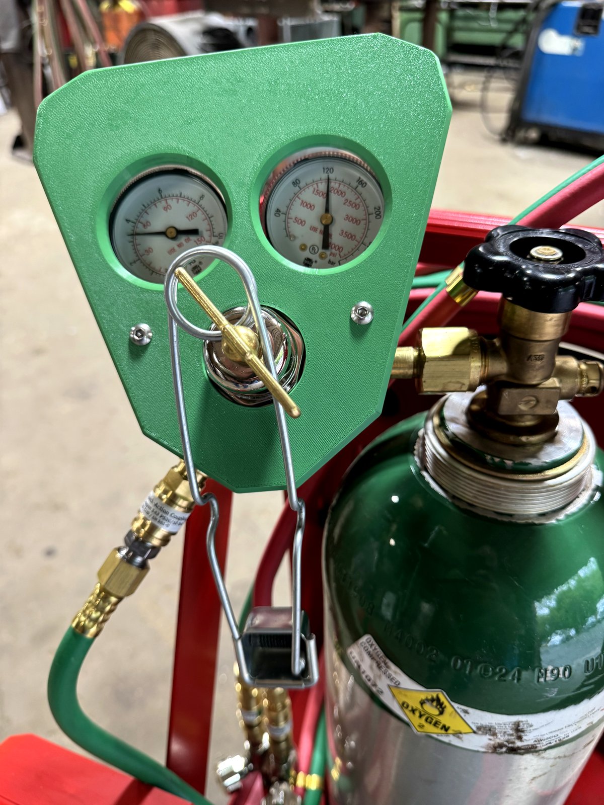 Green RegShield SM30 installed on an oxygen regulator, mounted to a tank with cylinder valve and brass fittings visible